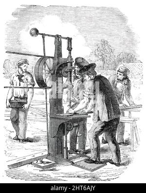 The Building in Hyde Park, for the Great Exhibition of 1851 - Drilling Machine, 1850. „Einer von Nathan Goughs vertikalen Vierpferd-Hochdruckmotoren wird verwendet, um die Bohr- und Stanzmaschinen zu bewegen, die in bequemen Abständen auf beiden Seiten platziert werden. Wir haben einen Überblick über jede dieser Maschinen gegeben. Auf der horizontalen Welle des Motors, die durch die Oberseite des Kessels geht, befinden sich drei Pullies verschiedener Durchmesser, von denen zwei Guttapercha und ein leathernband zu den beiden bereits erwähnten Maschinen führen. Die Bohrmaschine, die eine von Nasmyth's const ist Stockfoto