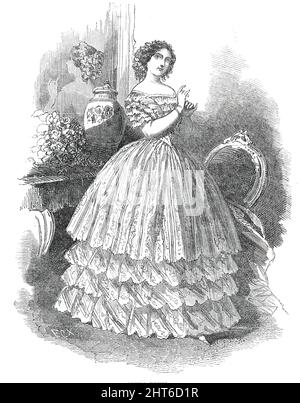 Pariser Mode für Juli - Opernkleid, 1850. „Das Opernkleid ist aus Seide, mit einem geraden Oberkleid und drei Volants am Kreuz; Der Körper spitz, mit einer Spitze berthe, mit fünf oder sechs Reihen Spitze der gleichen Art, aber deren Breite nimmt in jeder Reihe in der Annäherung an den Punkt des Körpers'. Aus „Illustrated London News“, 1850. Stockfoto