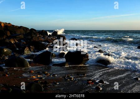 Wellen brechen auf den Felsen am Porth Ysgo Strand. Stockfoto