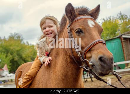 Glückliches kleines Mädchen Reiten Pony Pferd bareback und lachen Stockfoto