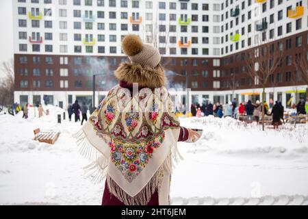 Rückansicht der Frau im traditionellen russischen Schal beim Winterfest maslenitsa Stockfoto