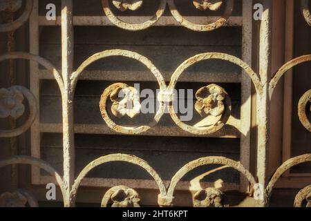Nahaufnahme eines schmiedeeisernen Fensterbedeckens mit einem Blumenmuster. Stockfoto