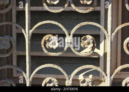 Nahaufnahme eines schmiedeeisernen Fensterbedeckens mit einem Blumenmuster. Stockfoto