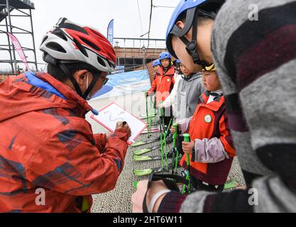 (220227) -- CHENGDU, 27. Februar 2022 (Xinhua) -- Coach Cao Jian (1. L) unterrichtet, wie Mitglieder des "Dieyun"-Ski-Teams in einer Trockenski-Trainingseinrichtung im Xindu-Bezirk in Chengdu, südwestlich der Provinz Sichuan, lernen, 25. Februar 2022. Wenn man die Jungen und Mädchen beim Skifahren auf der Piste sieht, wird niemand merken, dass sie etwas anderes sind als andere Ski-liebende Jugendliche, bis man bemerkt, dass ihr Trainer hauptsächlich durch Schreiben und Gestik mit ihnen kommuniziert. Alle 15 Mitglieder dieses Ski-Teams sind Schüler der Spezialschule im Bezirk Xindu in Chengdu, der Hauptstadt von Südwes Stockfoto