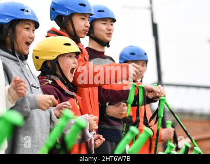 (220227) -- CHENGDU, 27. Februar 2022 (Xinhua) -- Mitglieder des "Dieyun"-Ski-Teams schauen sich bei einer Trainingseinheit in einer Trockenski-Trainingseinrichtung im Bezirk Xindu in Chengdu, südwestlich der chinesischen Provinz Sichuan, an, 25. Februar 2022. Wenn man die Jungen und Mädchen beim Skifahren auf der Piste sieht, wird niemand merken, dass sie etwas anderes sind als andere Ski-liebende Jugendliche, bis man bemerkt, dass ihr Trainer hauptsächlich durch Schreiben und Gestik mit ihnen kommuniziert. Alle 15 Mitglieder dieses Ski-Teams sind Schüler der Spezialschule im Bezirk Xindu in Chengdu, der Hauptstadt des südwestlichen Chinas Stockfoto