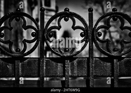 Das Gesims eines gusseisernen Tores mit einem rhythmischen Muster von Kreuzen. Stockfoto