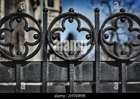 Das Gesims eines gusseisernen Tores mit einem rhythmischen Muster von Kreuzen. Stockfoto