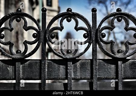 Das Gesims eines gusseisernen Tores mit einem rhythmischen Muster von Kreuzen. Stockfoto