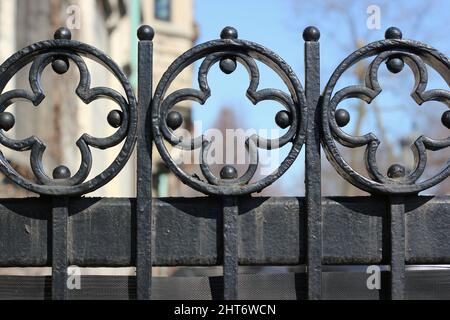 Das Gesims eines gusseisernen Tores mit einem rhythmischen Muster von Kreuzen. Stockfoto
