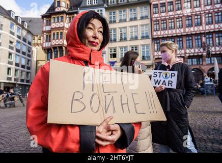Frankfurt, Deutschland. 27. Februar 2022, Hessen, Frankfurt/Main: Ein Demonstrator hält ein Plakat mit der russischen Inschrift 'Het Bonhe!!!' („kein Krieg!!!“) Bei einer Kundgebung auf dem Römerberg für den Frieden in der Ukraine und gegen die russische Invasion. Foto: Frank Rumpenhorst/dpa Quelle: dpa picture Alliance/Alamy Live News Stockfoto