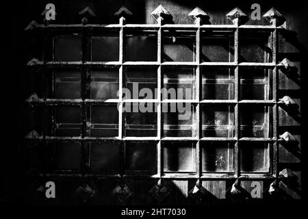 Das mittelalterliche Metallgitter an einer sicheren Holztür. Stockfoto