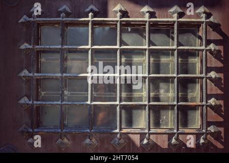 Das mittelalterliche Metallgitter an einer sicheren Holztür. Stockfoto