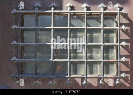 Das mittelalterliche Metallgitter an einer sicheren Holztür. Stockfoto
