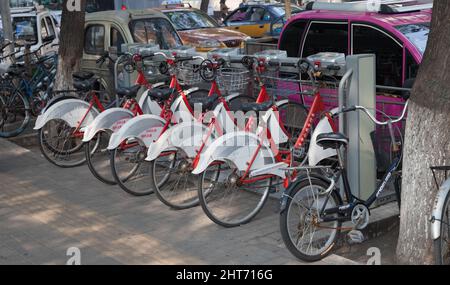 Eine Reihe von rot-weißen Fahrrädern zu mieten in Peking, China Stockfoto