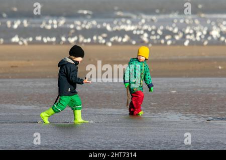 Southport, Merseyside, 27.02.22. Die Menschen machen das Beste aus den atemberaubenden frühlingshaften Bedingungen, wenn sie auf einen Spaziergang entlang der goldenen Küste von Southport Beach in Merseyside gehen. Quelle: Cernan Elias/Alamy Live News Stockfoto