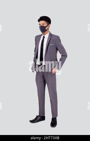 Portrait junge asiatische Geschäftsmann in Anzug tragen Gesichtsmaske für schützende covid-19 isoliert auf weißem Hintergrund, Geschäftsmann und Gesundheitswesen, quaranti Stockfoto