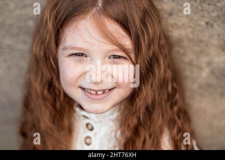 Porträt eines niedlichen, kleinen, Sommersprossen, Ingwer Mädchen im Hemd lächelnd Stockfoto