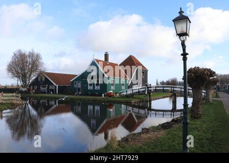 Traditionelles holländisches Bauernhaus an der Brücke entlang des Kanals im historischen Dorf Zaanse Schans in den Niederlanden, Januar 2022 Stockfoto