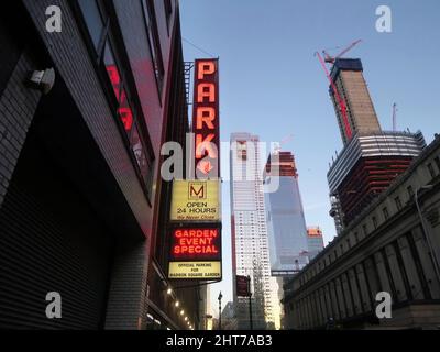 Aus dem unteren Winkel ein rotes neonfarbenes Parkschild mit Wolkenkratzern in Manhattan im Madison Square Garden. Stockfoto