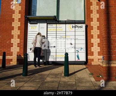 Eine Dame holt ein Paket von einem automatischen Amazon-Schließfach ab Stockfoto