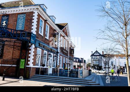 Epsom Surrey UK, Februar 27 2022, Wetherspoons Pub Building Exterior with People Walking under Clear Blue Sky Stockfoto