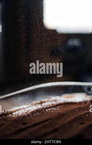 Nahaufnahme von Kakaopulver, das auf eine leckere Tiramisu-Schale fällt Stockfoto