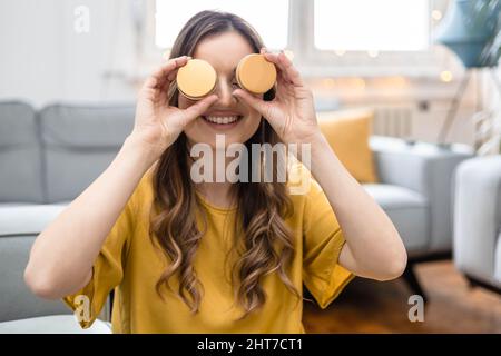 Junge Frau, die Kosmetikcreme in einem Behälter in den Händen hält und ihre Augen versteckt Stockfoto