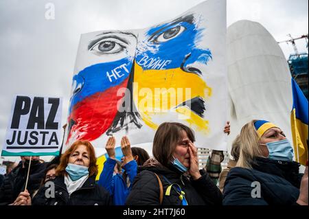 Madrid, Spanien. 27.. Februar 2022. Während einer Demonstration gegen die russische Invasion in die Ukraine wird eine Frau weinen sehen. In Madrid lebende Ukrainer und spanische Unterstützer (mehr als 12,000 laut Polizeibeamten) marschierten durch die Stadt und forderten das Ende des Krieges in der Ukraine und protestierten gegen den russischen Präsidenten Wladimir Putin. Quelle: Marcos del Mazo/Alamy Live News Stockfoto