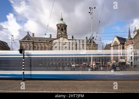 Stadt Amsterdam in den Niederlanden mit einer Straßenbahn, die am Königspalast Amsterdam vorbeifährt Stockfoto