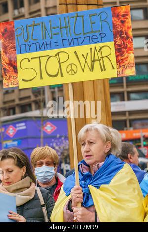 Ein Protestler hält ein Plakat mit der Aufschrift "Putin = Hitler, Stop war" während einer Antikriegsdemonstration auf der Plaza de España España, Madrid.ukrainische Anhänger versammeln sich am fünften Tag, nachdem Russland das Gebiet der Ukraine angegriffen hatte, um gegen den Krieg zu protestieren. Stockfoto