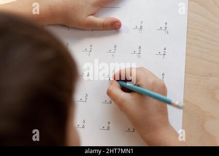 Ein Schuljunge, der Mathematik unterrichtet, sitzt am Schreibtisch im Kinderzimmer Stockfoto