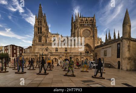 Malerischer Blick auf die Kathedrale von Burgos vor bunten Metallfiguren auf blauem Himmel Stockfoto