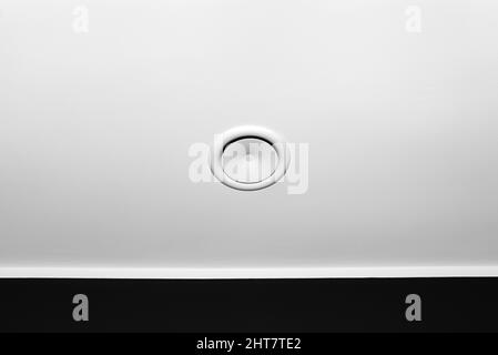 Häusliche mechanische Lüftung mit Wärmerückgewinnung, sichtbarer Blasanemostat an der Decke im Raum, schwarze Wand. Stockfoto