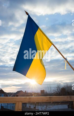 Ukrainische Flagge flattert im Wind und Sonnenlicht gegen den Sonnenuntergang Himmel. Nationales Symbol der Freiheit und Unabhängigkeit.. Russlands Invasion der Ukraine, S Stockfoto