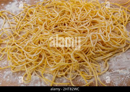 Italienische Spaghetti alla chitarra auf Holzschneidebrett, hausgemachte frische Pasta aus den Abruzzen und Apulien Stockfoto