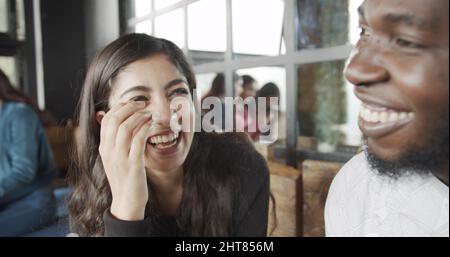 Schöne indische Frau, die ihren männlichen Freund vor einem verschwommenen Hintergrund ansieht Stockfoto