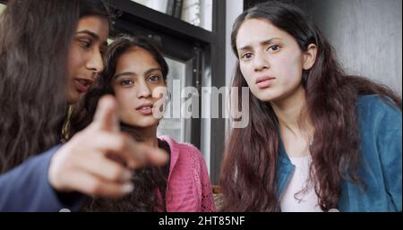 Gruppe von indischen jungen Frauen, die mit ernsten Gesichtern auf die Kamera schauen Stockfoto