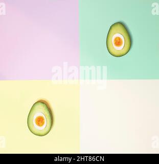 Avocado und Ei auf pastellfarbenem Hintergrund. Kreatives, flaches Lay. Stockfoto