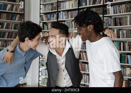 Fröhliche Millennial multirassischen College-Freunde, die Spaß auf dem Campus. Stockfoto
