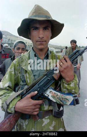 KABUL, AFGHANISTAN. 15. Mai 1988. Ein afghanischer Dorfmiliz-Soldat zeigt sein AK-47 Gewehr, das mit einem Foto einer Frau am 2. Mai 1988 vor Kabul, Afghanistan, geschmückt ist. Die sowjetische Armee wird am 15.. Mai mit dem Rückzug aus Afghanistan beginnen. Stockfoto