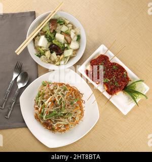 Nahaufnahme einer chinesischen Mahlzeit für eine kleine Familie, einschließlich Nudeln, grünes Gemüse, Quark-Snack Stockfoto