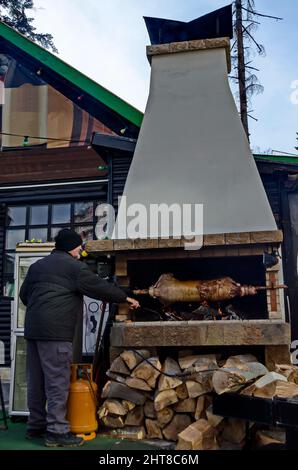 Lamm, gebraten ganz auf einem Spieß über einem offenen Feuer in einer modernisierten Umgebung im Ferienort Borovets, Rila Mountain, Bulgarien Stockfoto