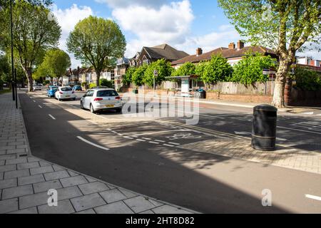 Ein geschützter Radweg auf einer Straße in einem Vorort von West London. Stockfoto