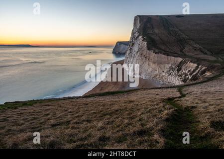 Die Sonne geht über den Kreidefelsen von bat's Head in der Nähe von Lulworth an der Jurassic Coast von Dorset unter. Stockfoto