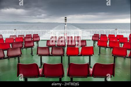 Die Sitzplätze auf dem Außendeck der Arran Ferry sind an einem grauen Tag auf dem Firth of Clyde vor der Küste von Ayrshire in Schottland leer. Stockfoto