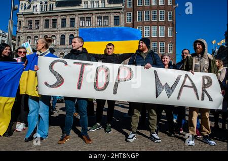 Amsterdam, Niederlande. 27.. Februar 2022. Während eines Antikriegsproteste gegen die russische Invasion in die Ukraine halten Demonstranten ein Plakat mit der Aufschrift "Stop war".die ukrainische Gemeinschaft, die russische Gemeinschaft und mehrere Nichtregierungsorganisationen in den Niederlanden versammelten sich auf dem Dam-Platz, um gegen Putin und die russische Invasion der Ukraine zu protestieren. Kredit: SOPA Images Limited/Alamy Live Nachrichten Stockfoto