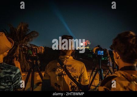 Petchaburi, Thailand. 27.. Februar 2022. Lokale Fotografen fotografieren auf einer Brücke während eines Feuerwerks in Petchaburi.das Phra Nakhon Khiri Festival findet in Petchaburi, Thailand statt. Das jährliche Fest zum Gedenken an König Rama IV. Umfasst eine Licht- und Feuerwerksanzeige rund um Phra That Chom Phet Chedi im Phra Nakhon Khiri Historial Park, einem ehemaligen königlichen Sommerpalast. Kredit: SOPA Images Limited/Alamy Live Nachrichten Stockfoto