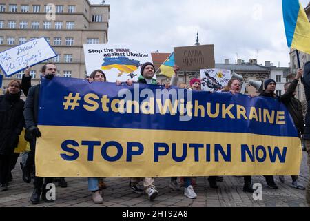 Krakau, Polen. 27.. Februar 2022. Demonstranten halten während der Demonstration ein Banner und Plakate in der Hand.Ukrainer in Krakau protestieren gegen den Krieg in der Ukraine und Putins Aggression gegen ihr Land. Kredit: SOPA Images Limited/Alamy Live Nachrichten Stockfoto