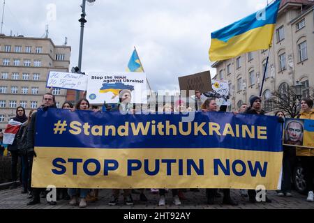 Krakau, Polen. 27.. Februar 2022. Demonstranten halten während der Demonstration ein Banner und Plakate in der Hand.Ukrainer in Krakau protestieren gegen den Krieg in der Ukraine und Putins Aggression gegen ihr Land. Kredit: SOPA Images Limited/Alamy Live Nachrichten Stockfoto