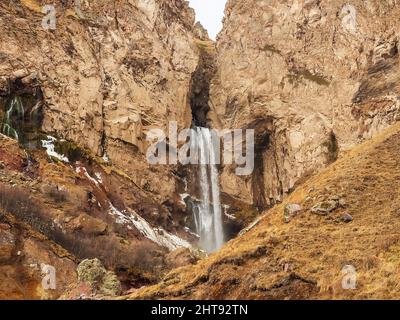 Ein hoher stürmischer Wasserfall, der am Herbsttag in den massiven Felsen von Djily-su herabfließt. Reise durch die Bergschönheiten des Kaukasus Stockfoto